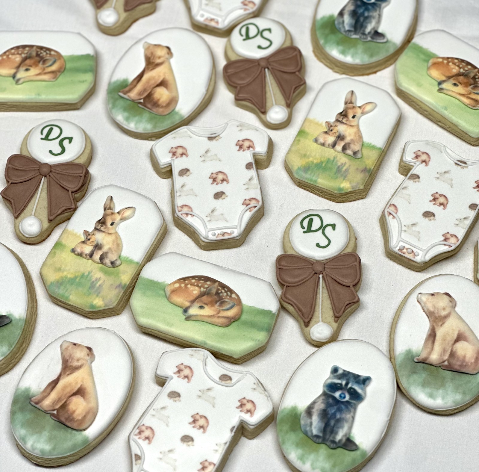 DS Woodland baby shower cookies — watercolor fawn, bunnies, raccoon, and onesie with DS monogram